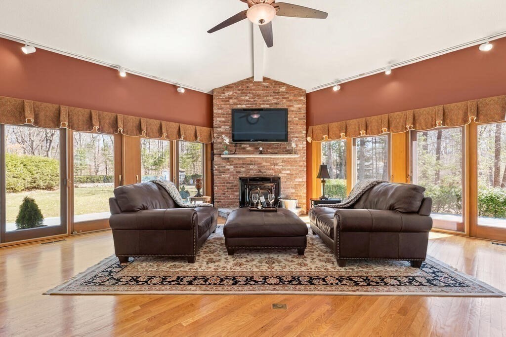 18 Appleton Lane Boxford, MA 01921 - Photo 14 of 42 a living room with couches a flat screen tv and a fireplace