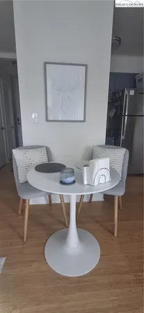 a living room with table chairs and a wooden floor