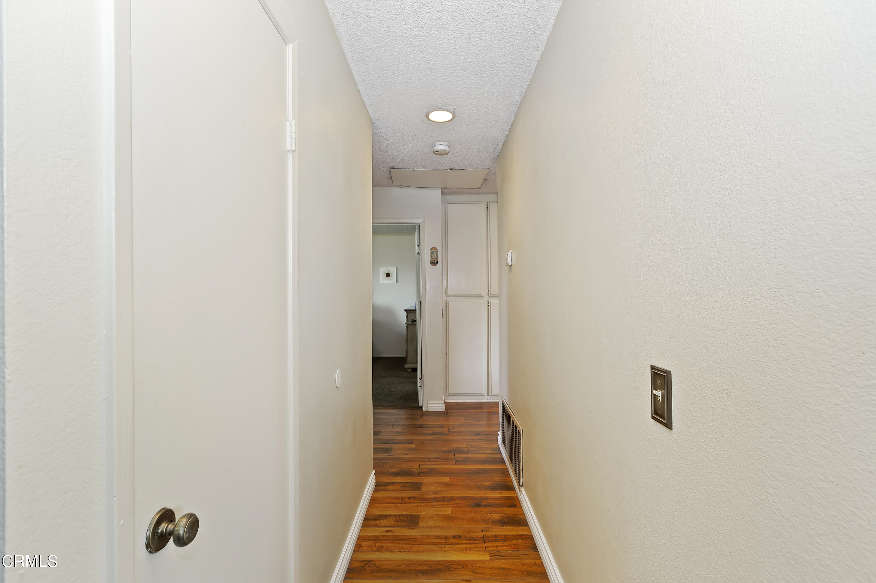 9245 Devon Street Rancho Cucamonga, CA 91730 - Photo 13 of 22 a view of a hallway with wooden floor and a bathroom