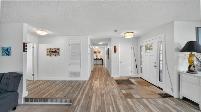a view of a living room hardwood floor and a window
