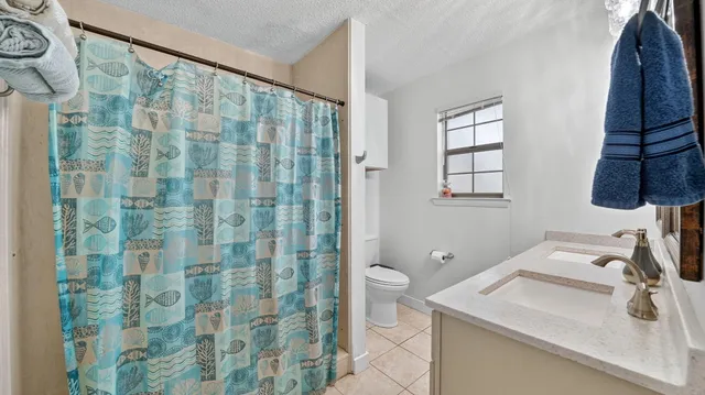 a view of a house with a yard tree and a fence