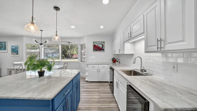 a kitchen with a sink a counter space cabinets and appliances