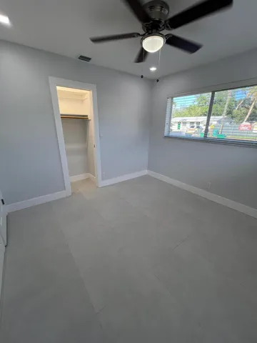 en empty room with windows and ceiling fan