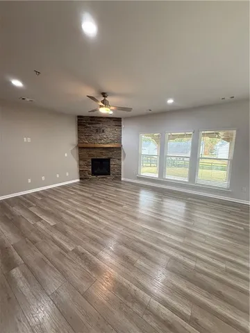 an empty room with windows and fireplace