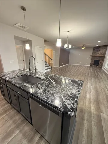 a kitchen with kitchen island granite countertop a sink and a stove