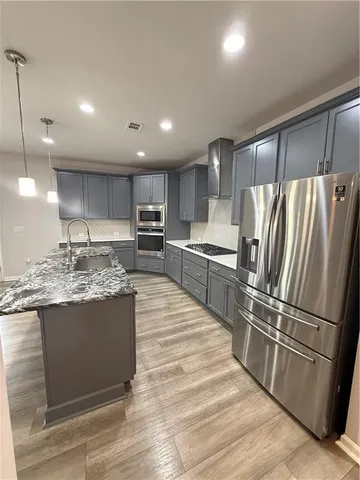 a kitchen with granite countertop a refrigerator and a sink
