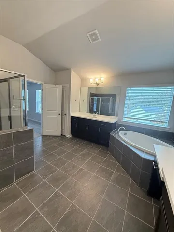 a bathroom with a tub shower and sink