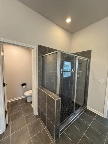 a bathroom with a glass shower door and a toilet