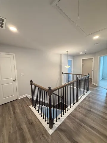 a view of a hallway with wooden floor and windows