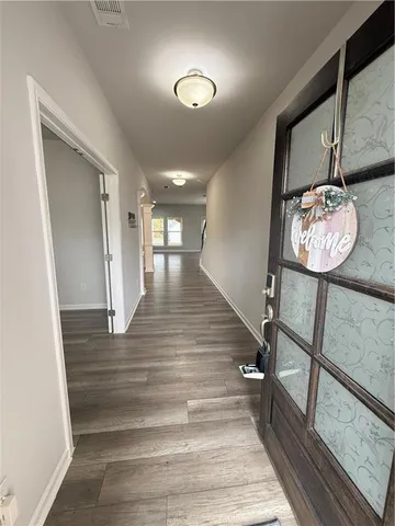 a view of entryway and hall with wooden floor