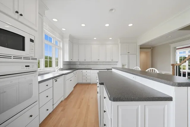 a large kitchen with granite countertop a sink and dishwasher stove top oven