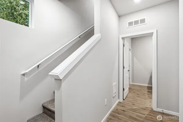 a view of a hallway with wooden floor and entryway