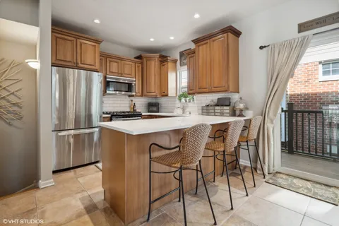 a kitchen with stainless steel appliances granite countertop a refrigerator a stove a sink and a microwave