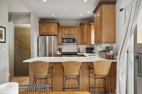 a kitchen with stainless steel appliances granite countertop a refrigerator and a stove top oven