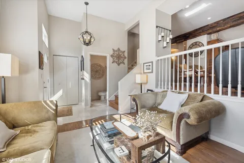 a living room with furniture a dining table and a chandelier