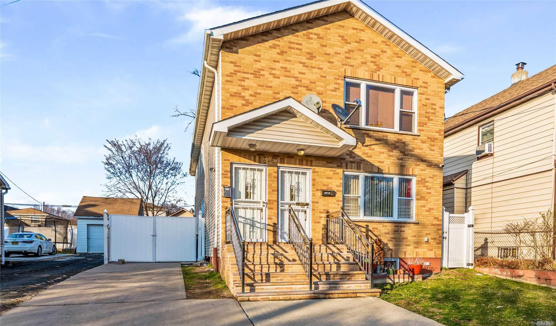 219-31 143rd Road Queens, NY 11413 - Photo 1 of 1 a view of a white house with many windows next to a road