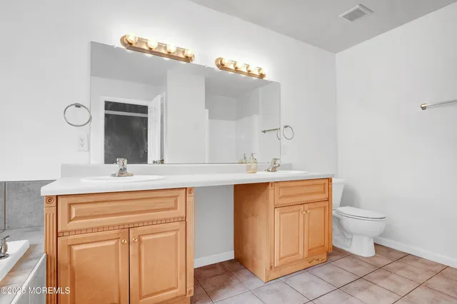 a bathroom with a sink a toilet and mirror