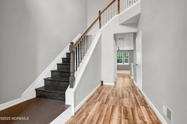 a view of entryway and hall with wooden floor