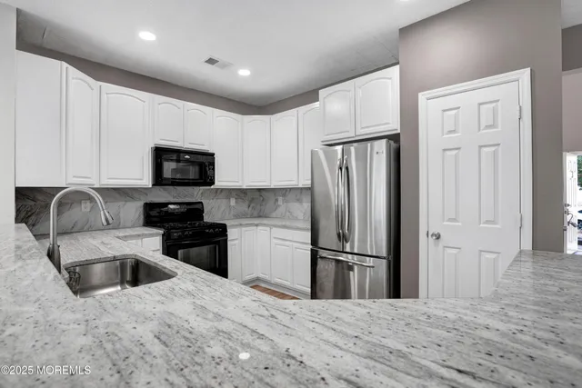 a kitchen with stainless steel appliances granite countertop a refrigerator stove microwave and sink