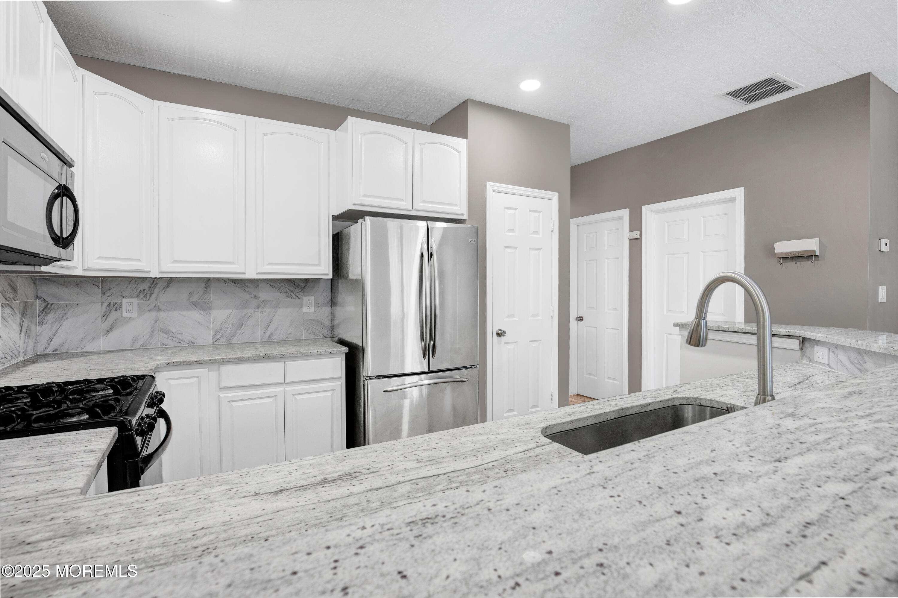 100 Pine Street, Unit 3 Lakehurst, NJ 08733 - Photo 10 of 20 a kitchen with stainless steel appliances kitchen island a refrigerator sink and cabinets