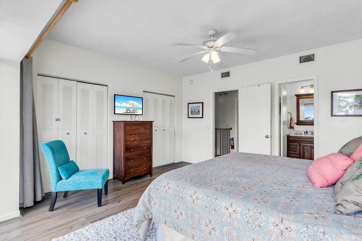 140 Aregood Lane, Unit C2 Islamorada, FL 33036 - Photo 23 of 49 a spacious bedroom with a bed and a chandelier