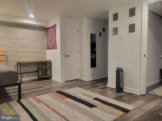 a view of a hallway with wooden floor and cabinet