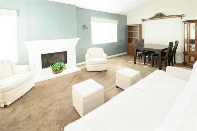a living room with furniture a fireplace and a large window
