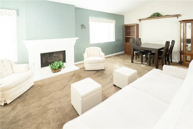 a living room with furniture a fireplace and a large window