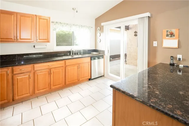 a large kitchen with kitchen island granite countertop a sink and a white cabinets