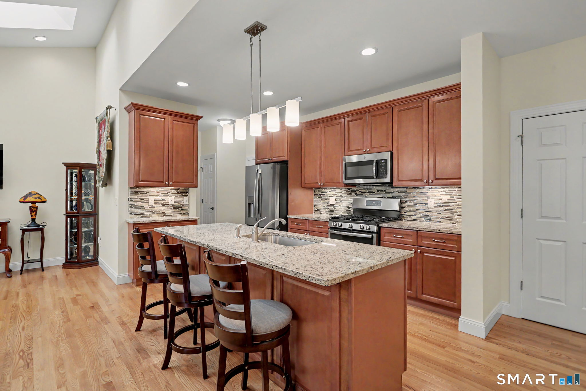 223 Meadow Brook Road, Unit 223 Oxford, CT 06478 - Photo 33 of 34 a kitchen with stainless steel appliances granite countertop a stove top oven a refrigerator a sink and chairs