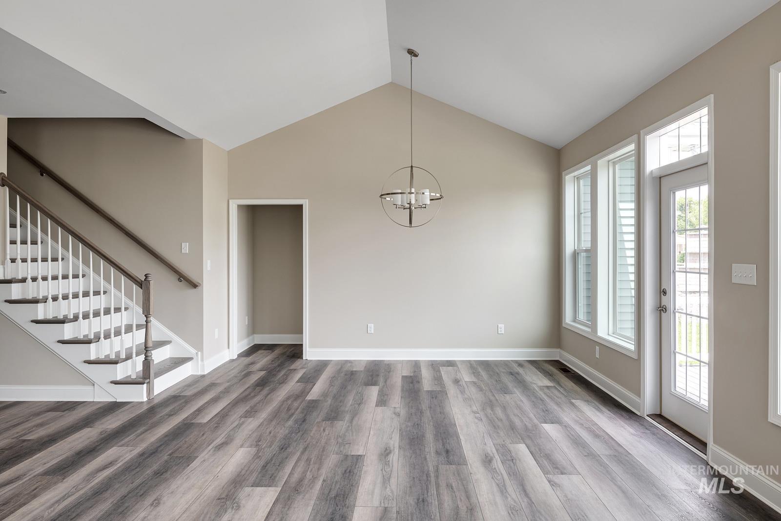 7297 West Lands Street Eagle, ID 83616 - Photo 5 of 5 Unfurnished dining area with stairs, a chandelier, vaulted ceiling, and light wood-style floors