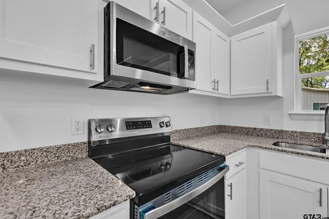 a kitchen with a stove microwave and sink