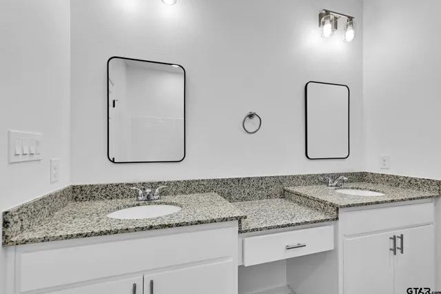 a bathroom with a granite countertop sink and mirror