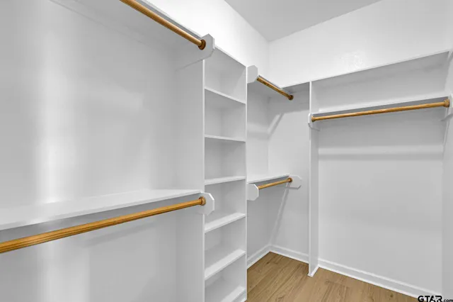 a view of walk in closet with wooden floor