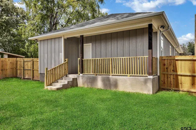 a view of backyard with barbeque grill and wooden fence