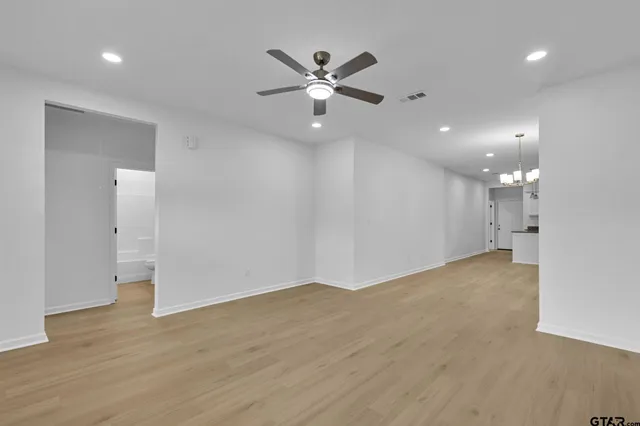 a view of an empty room with a ceiling fan