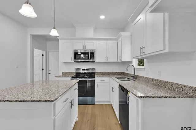 a kitchen with stainless steel appliances granite countertop a sink stove and refrigerator