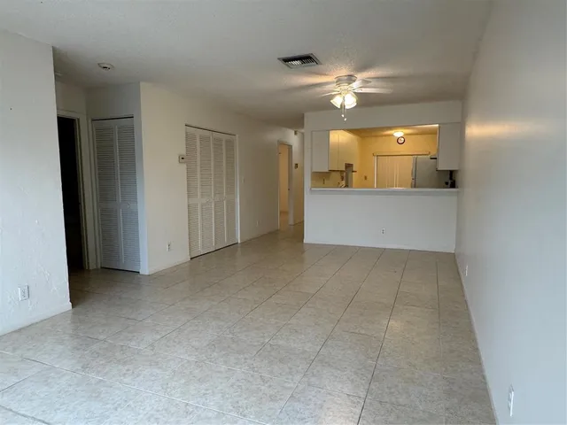 an empty room with a bathroom and mirror