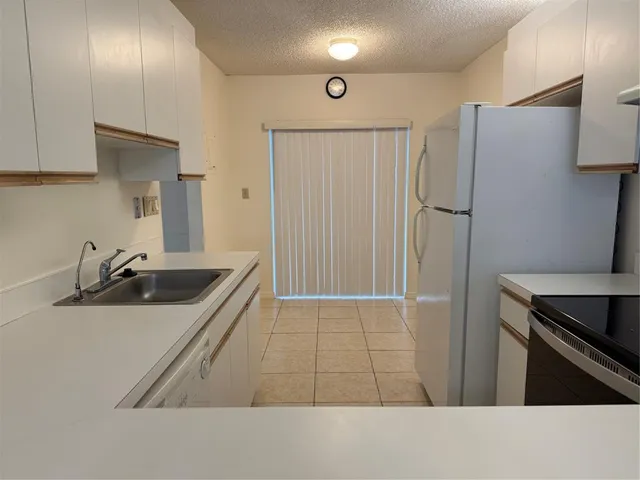 a kitchen with stainless steel appliances a sink stove and refrigerator