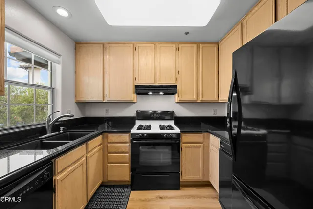 a kitchen with a sink stove top oven and cabinets