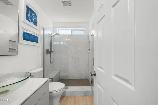a bathroom with a granite countertop toilet a sink and a mirror