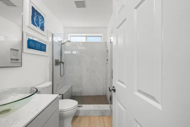 a bathroom with a granite countertop toilet a sink and a mirror
