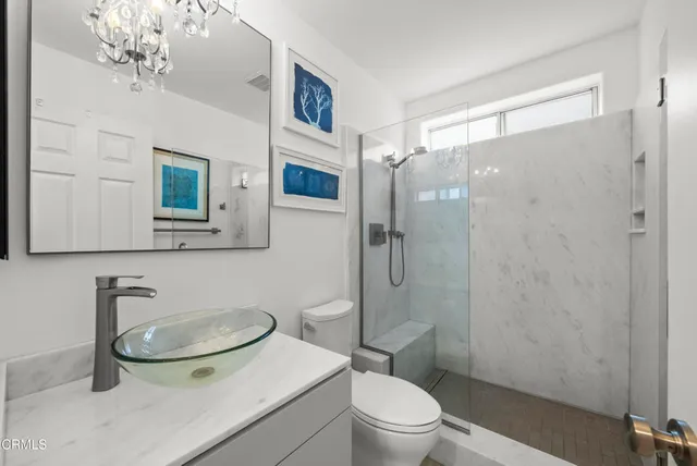 a bathroom with a sink a toilet and shower