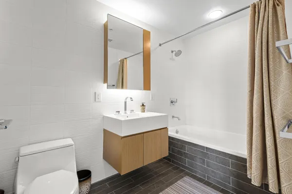 a bathroom with a sink mirror toilet and bathtub