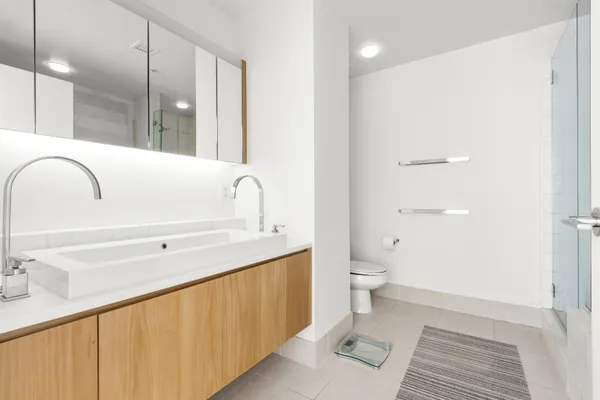 a spacious bathroom with a granite countertop sink a toilet and a mirror