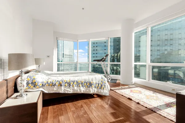 a large bed sitting in a bedroom next to a window
