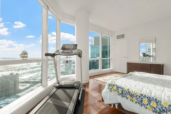 a bedroom with a large bed and a large window with outer view