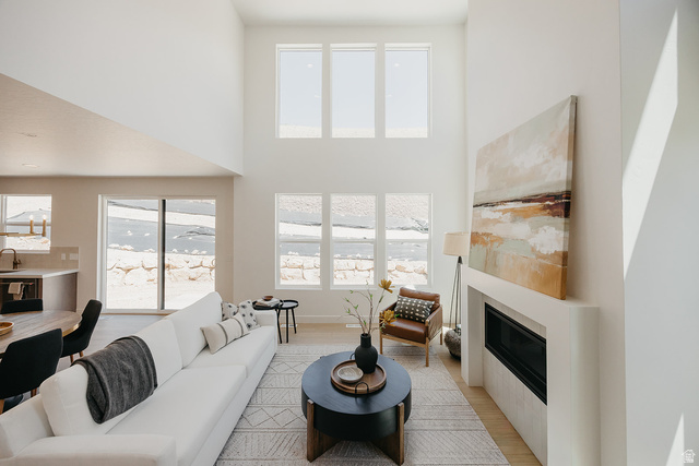 5902 Canyon Rim Road, Unit 620 Lehi, UT 84048 - Photo 19 of 78 Two-story living area featuring a modern fireplace, multiple large windows, light wood-finish flooring, and high ceilings