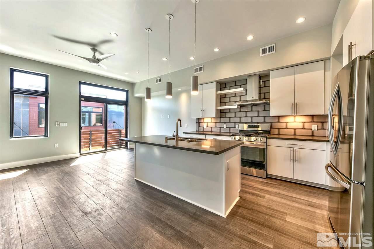 504 Mill Street Reno, NV 89502 - Photo 4 of 22 a kitchen with stainless steel appliances granite countertop a refrigerator a sink dishwasher a stove and white countertops with wooden floor