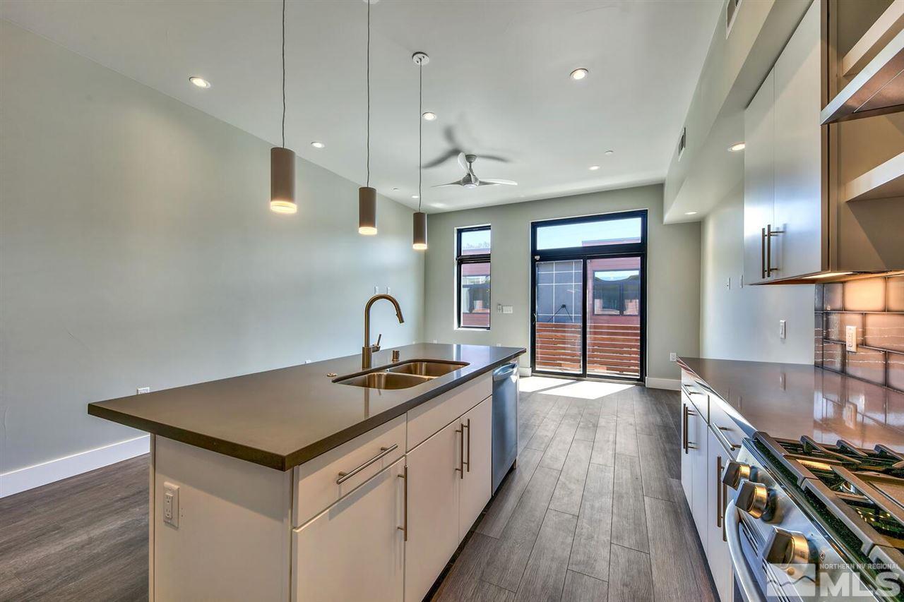 504 Mill Street Reno, NV 89502 - Photo 5 of 22 a kitchen that has a lot of cabinets a sink and wooden floor